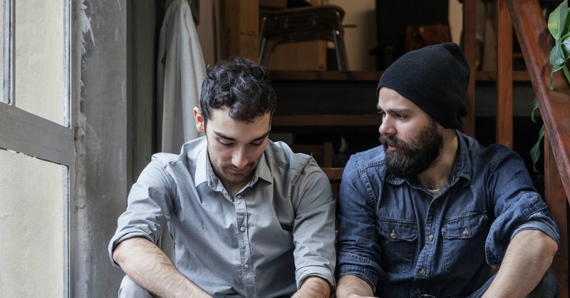 man listening to sad friend bearing one another's burdens