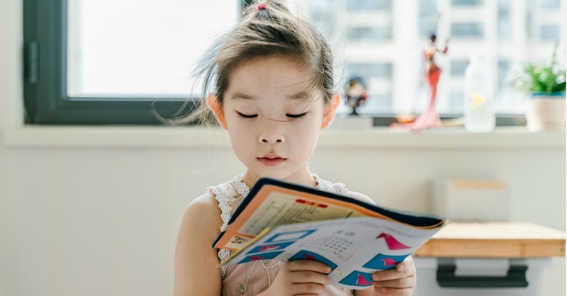 young girl reading picture book