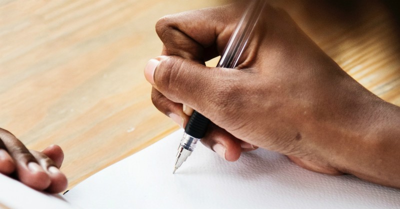 woman writing on paper