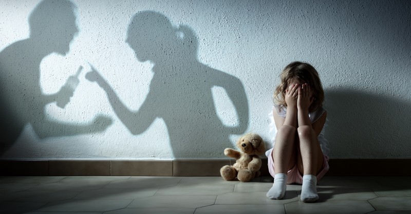 parents fighting while child cries in corner