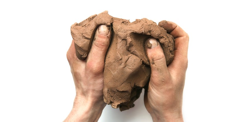 Hands working a lump of clay
