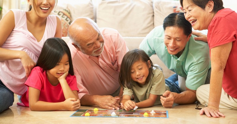 family playing board game together on floor