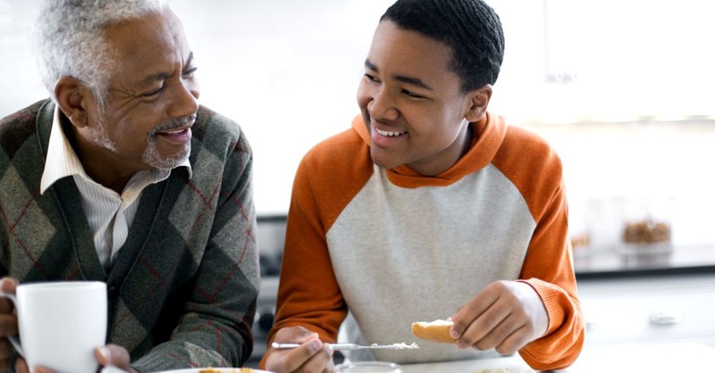 grandfather talking with grandson at breakfast