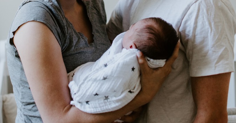 parents holding baby