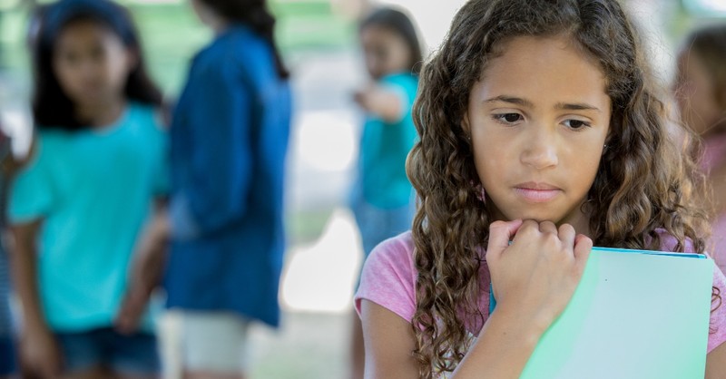 girl looking upset bullied by other girls