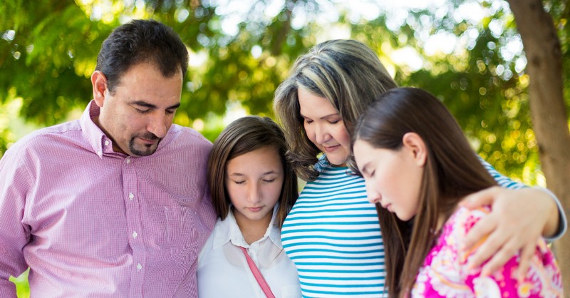 family heads bowed in prayer