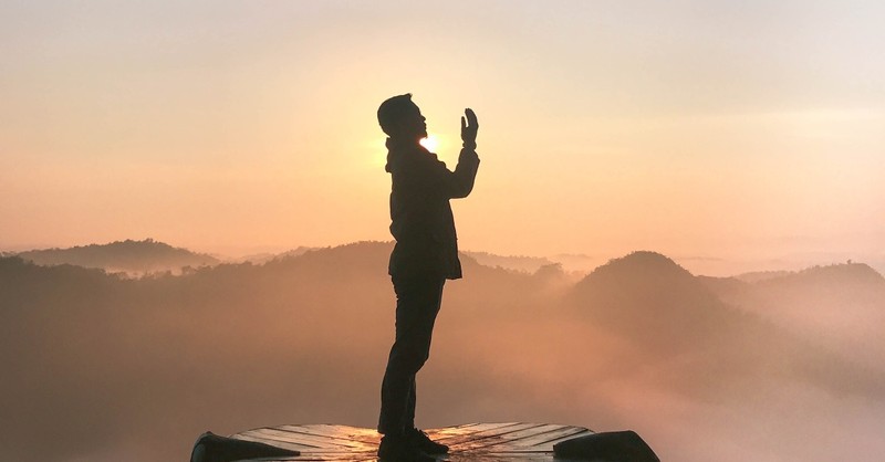 man praying on mountain top