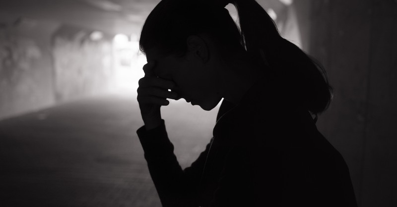 woman silhouette looking distressed holding head, battle plan for depression