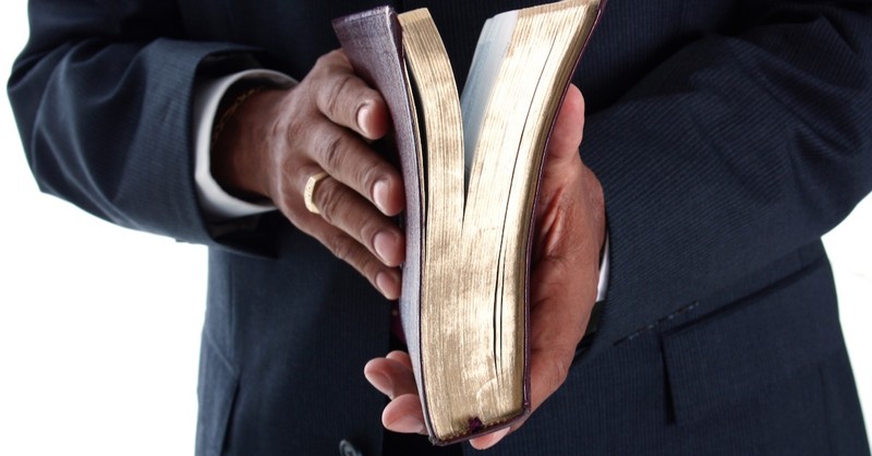 man's hands holding bible, marks of a church you can trust