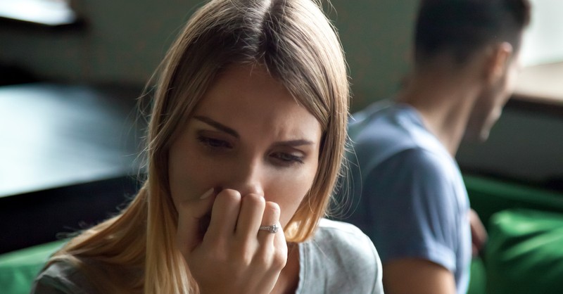 woman turning from husband looking upset