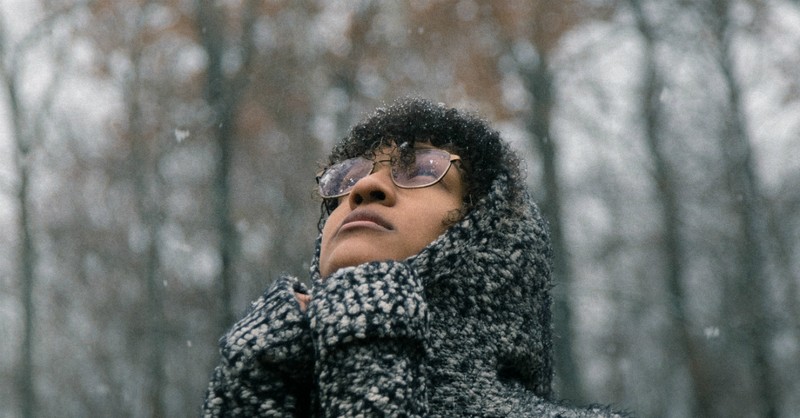 woman looking up at falling snow, for everything there is a season