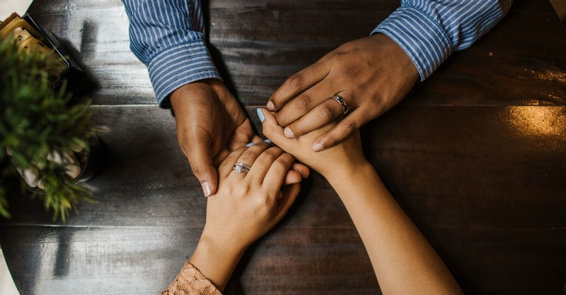 hands holding across table, unequally yoked