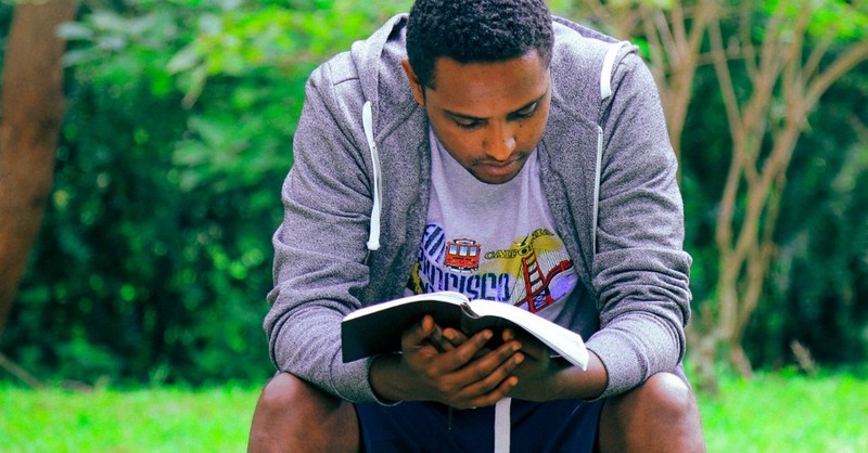 Man reading a Bible outside