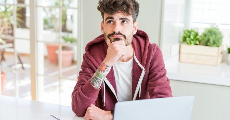 man sitting in coffee shop with wondering expression, is it a sin to question God