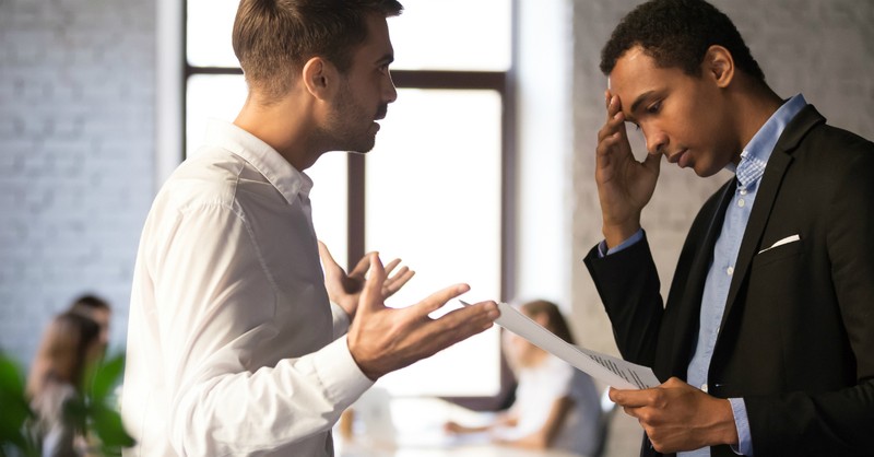 man yelling at coworker or employee looking upset