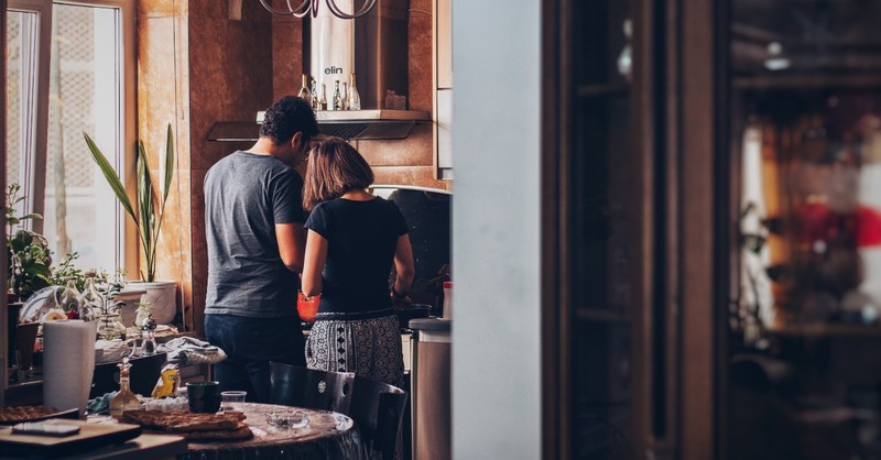 couple cooking together at the stove