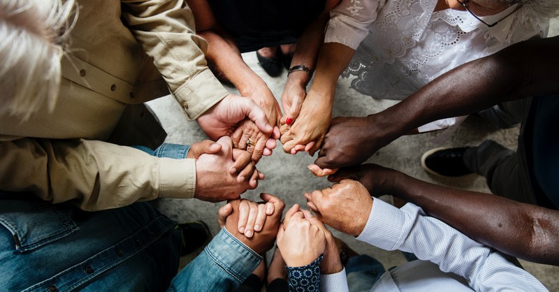 group of people holding hands in circle