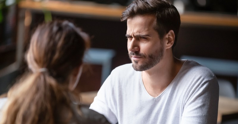 man looking skeptically at woman