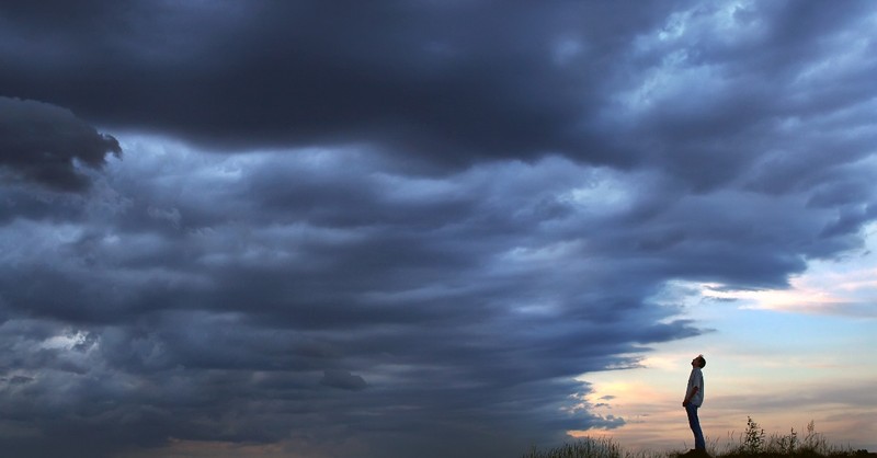 man standing looking at storm