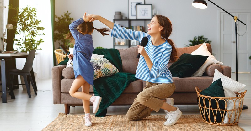 mom with microphone and daughter dancing in living room worship