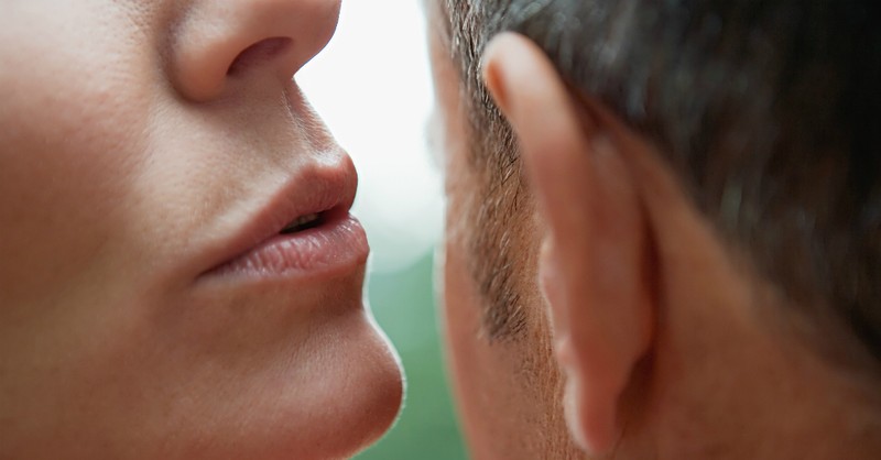 woman whispering a lie to a man