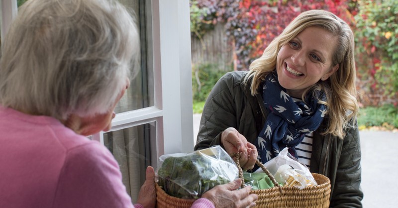 woman giving groceries to elderly lady