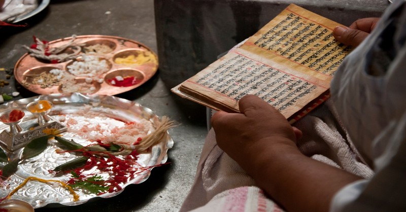 Hindu person reading text, origin of the word karma
