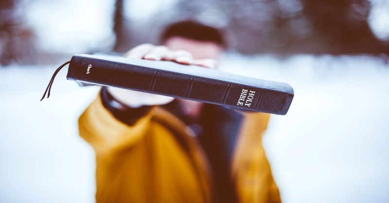 Person holding Holy Bible, obedience is better than sacrifice