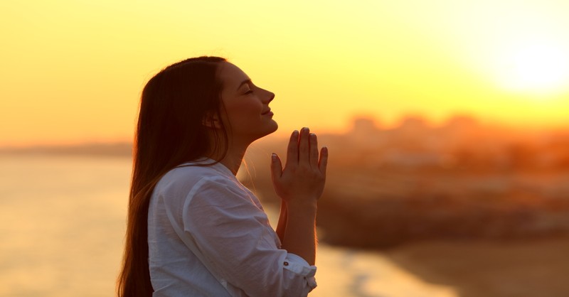 woman praying and looking above at sunset, obedience is better than sacrifice