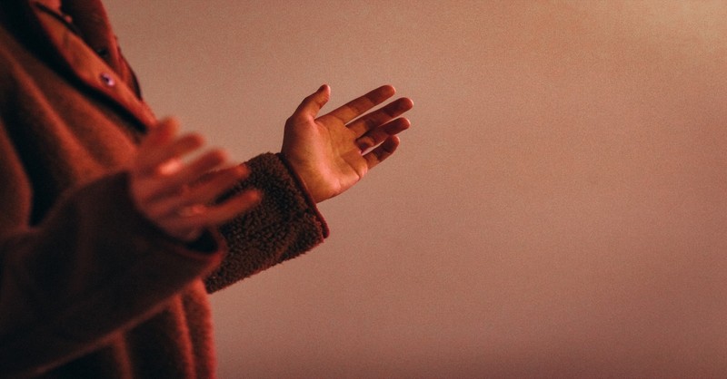 person wearing red sweater worshipping, today is the day the lord has made