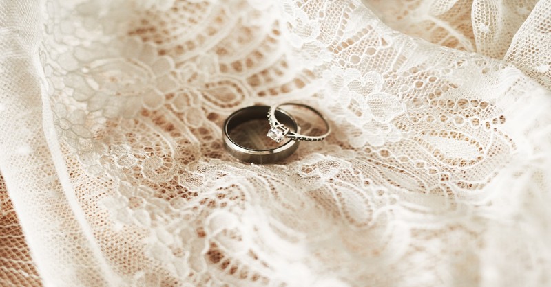 wedding rings on top of a wedding dress, leave and cleave
