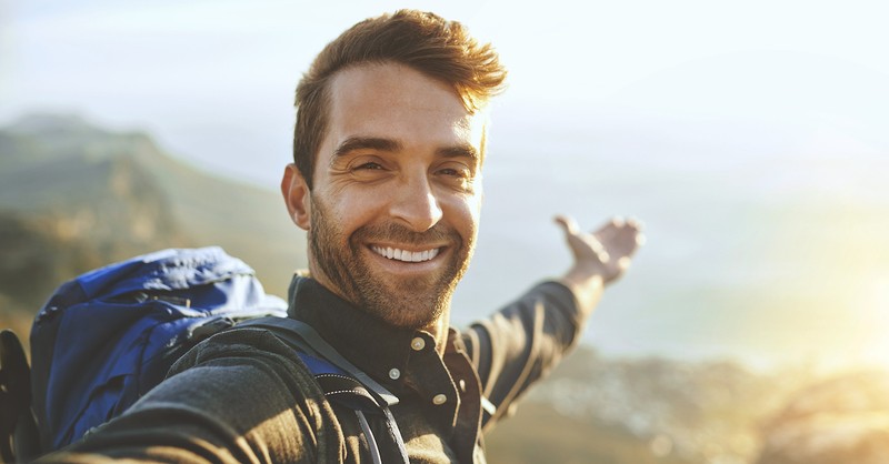 Happy single man hiking on mountain