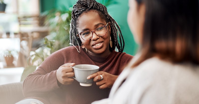 Freundinnen trinken Kaffee und reden auf der Couch