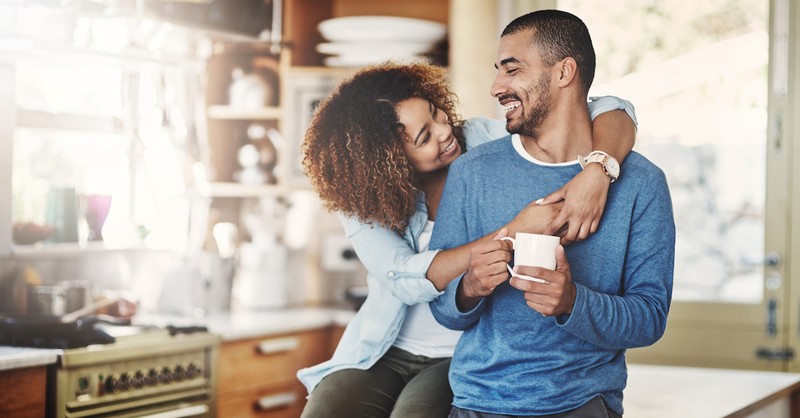 Happy couple hugging in kitchen