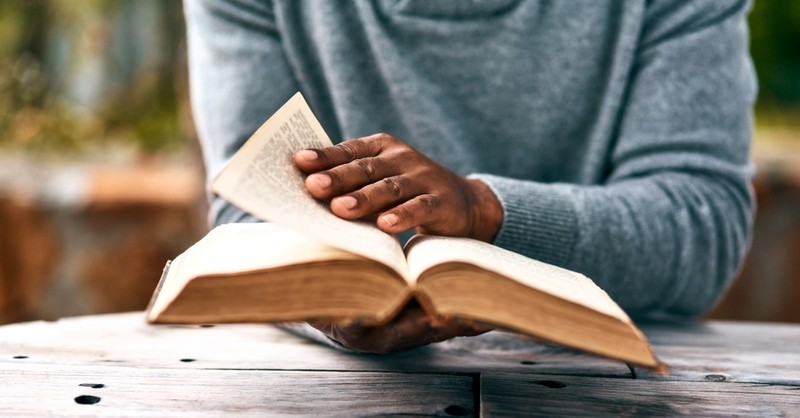 African-American man reading bible outside neck down photo