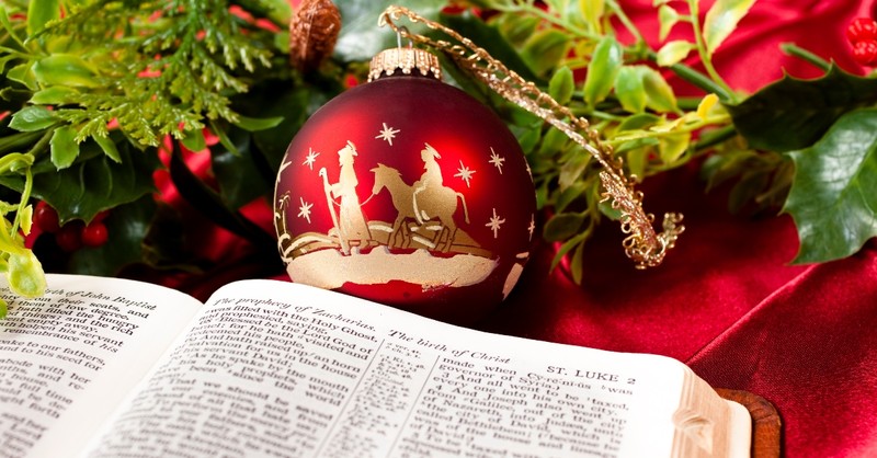 Open Bible surrounded by Christmas decorations
