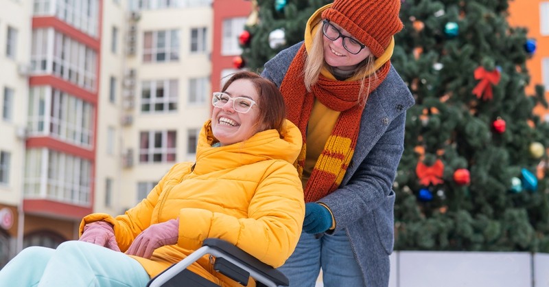 Two women, one in a wheelchair, outside at Christmas