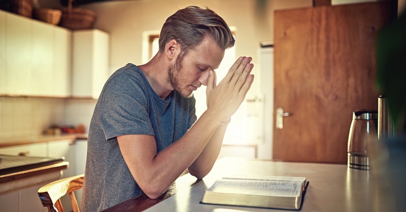 Man praying over Bible