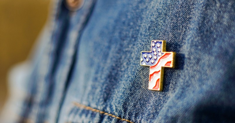 Cross pin with American flag on a jean jacket