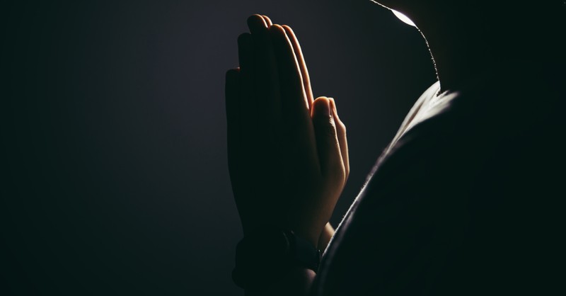praying hands in the dark