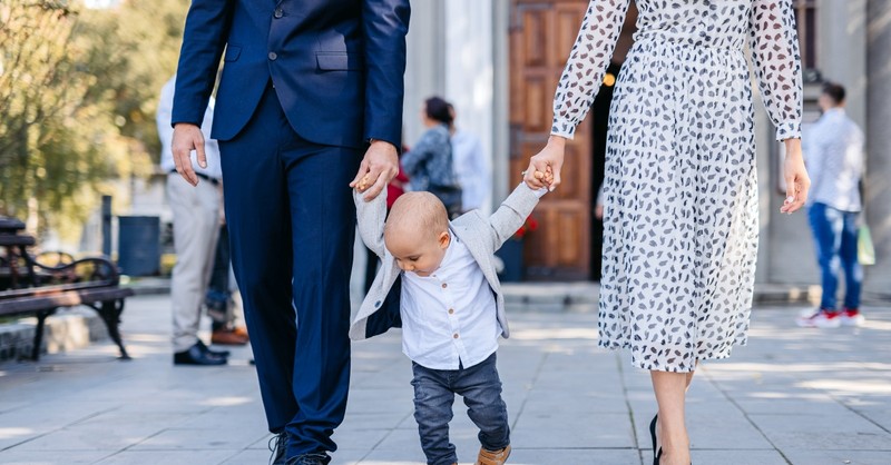 Couple with their baby walking out of church
