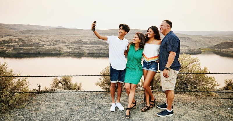 Family with two teens on vacation, taking a selfie