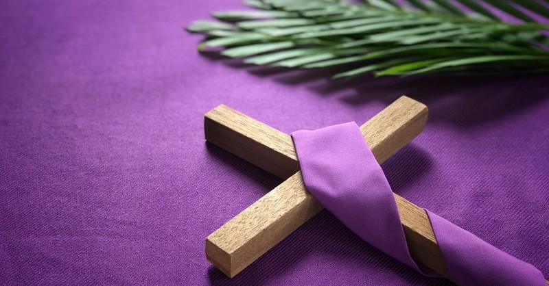 easter cross and palm leaf on purple background