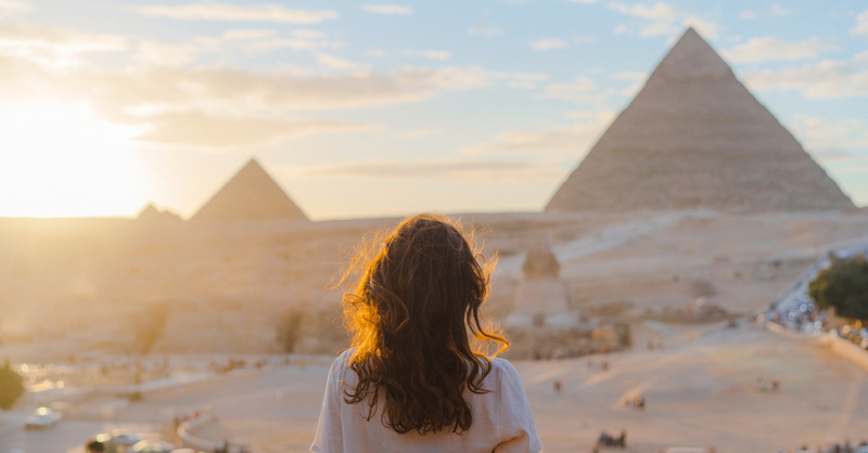 Woman looking at Egyptian Pyramids from afar.