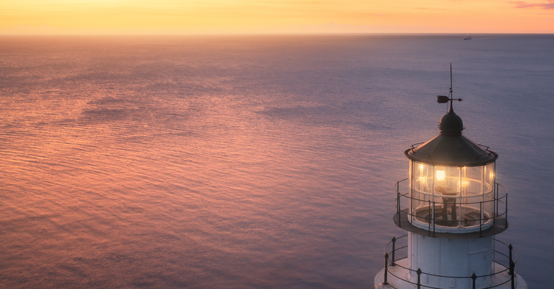 Lighthouse at sunrise, a boat in the distance; God is the strength of our hearts.