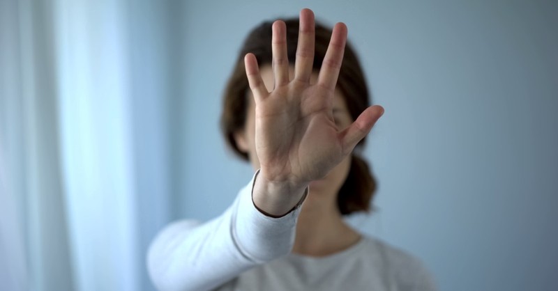 woman holding up hand to indicate "no," why people reject christianity