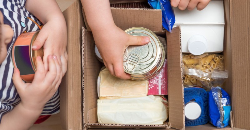 kids packing meals in a cardboard box