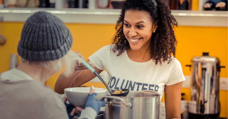 Woman serving soup at a soup kitchen; serving is good for the soul.