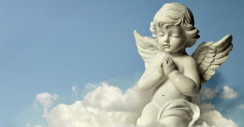 praying cherub statue riding a cloud