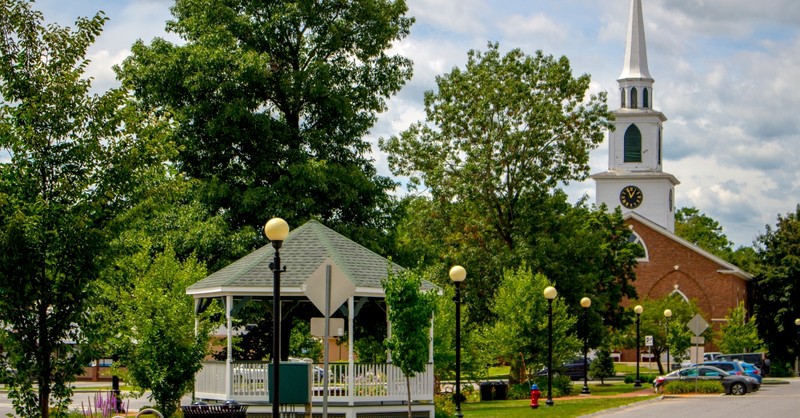 Small town neighborhood with a gazebo and a church in the background